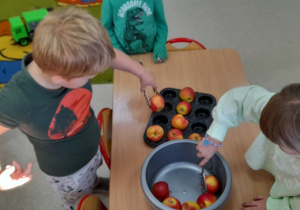 dzieci bawią się z wykorzystaniem jabłek
